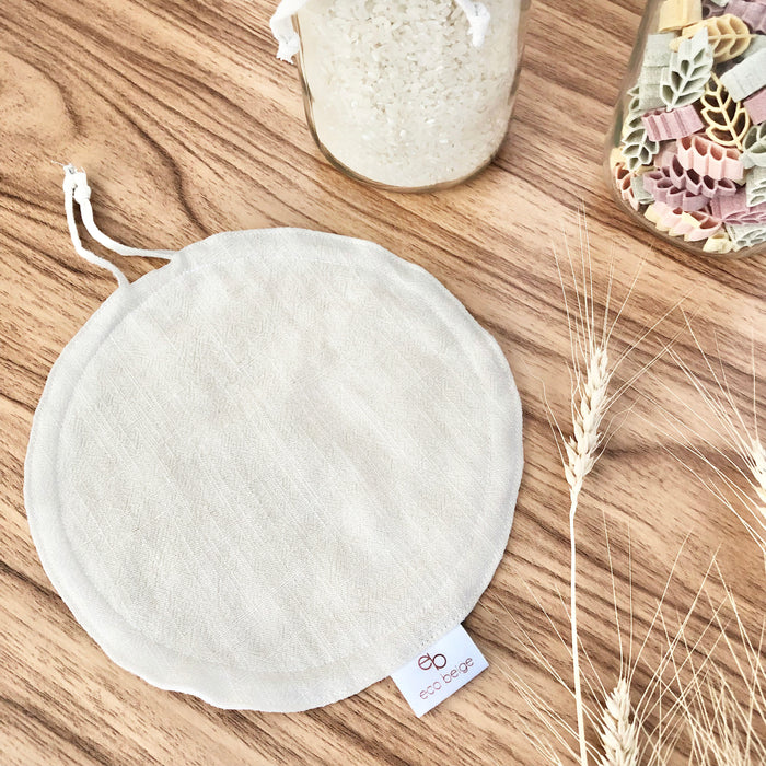 Eco Beige handmade Linen fabric jar cover laying flat on wood counter with wheat straws and dry bulk food jars.