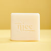 Natural unscented solid dish soap block with Make Nice Company logo pressed into the block. Contrasting yellow background color.