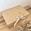 Beautiful Kraft color scallop gift box with beige ribbon and dried floral decor.