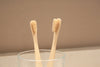 Eco-friendly bamboo toothbrush with Eco Beige engraved.  Beige minimalist background.