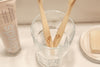 Eco-friendly bamboo toothbrush with Eco Beige engraved. Minimal style background with natural toothpaste and soap bar.