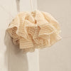 Natural ramie bath pompom hanging in the bathroom for body exfoliating.