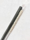 Black stainless steel straw with natural sisal straw brush set in white background.