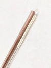 Rose gold stainless steel straw with natural sisal straw brush set in white background.