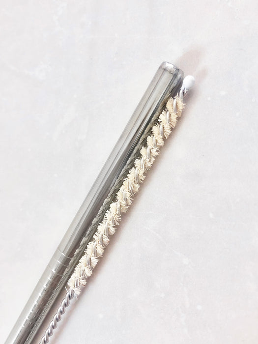 Silver stainless steel straw with natural sisal straw brush set in white background.