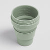 Sage color Stojo cup in 16oz. Top view with ml and oz capacity bar showing inside. White background.