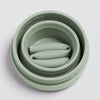 Sage color Stojo cup in 16oz. Collapsed top view with folded straw inside. White background.